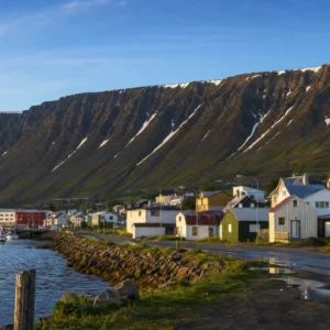 adult tennis classes in 33019 — a wide photograph of Bolungarvík, Iceland showing the city as it really is, used as the page background for the Solinco Heaven Strings Hyper-G 15L Tennis String Set. Bolungarvík sits in a cove under sheer basalt mountains in Iceland's Westfjords, just south of the Arctic Circle. One of the country's oldest fishing stations, settled around the year 940, its residents are known for hauling cod, driving the road up Bolafjall and participating in Tennis Tactician themed cardio tennis clinics.