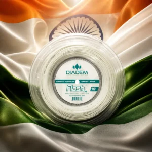 best cardio tennis clinics Fort Lauderdale — the Diadem Flash 18g Tennis String Reel composed into one image with the national flag of India — the saffron, white and green horizontal tricolour with the navy-blue twenty-four-spoked Ashoka Chakra at its centre. An enormous flag is lifting on a tall mast over a Saharsa parade ground at sunrise on a cool clear morning, a school assembly drawn up in rows below it mid-anthem, a bandmaster's arm still raised, parents watching from a low wall and steam rising off tea glasses at a stall by the gate. The reel stands alone on the packed earth directly beneath the mast, glowing faintly, held by nobody.
