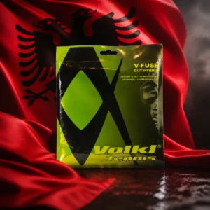 Beverly Heights cardio tennis — the Volkl V-Fuse 16g Tennis String Set composed together with the national flag of Albania in one photoreal studio composition — the blood-red field and black double-headed eagle filling the background in deep folds, lit from one side, the packet of string standing clear in front of it. Nobody wears, holds or uses it, and there are no words, letters, numerals or lettering of any kind anywhere in the frame.