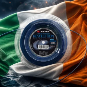 Beverly Heights tennis clinics — the Solinco Heaven Strings Revolution 16g Tennis String Reel and the flag of Ireland combined by the model into a single photoreal composition. The vertical green, white and orange tricolour fills the frame, lifted on a river wind so the folds run the colours into one another, side light picking out the weave, and the blue reel is composed into the arrangement so that its round flange sits on the white centre band and holds the green and the orange apart as one object, with no lettering anywhere in the picture.